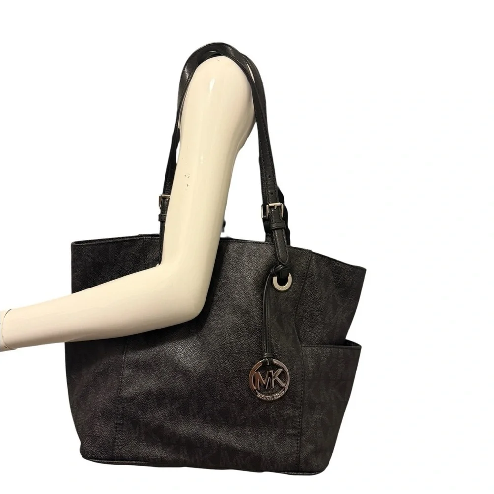 Michael Kors Elegant Black Handbag. Sides packets with a log in the front